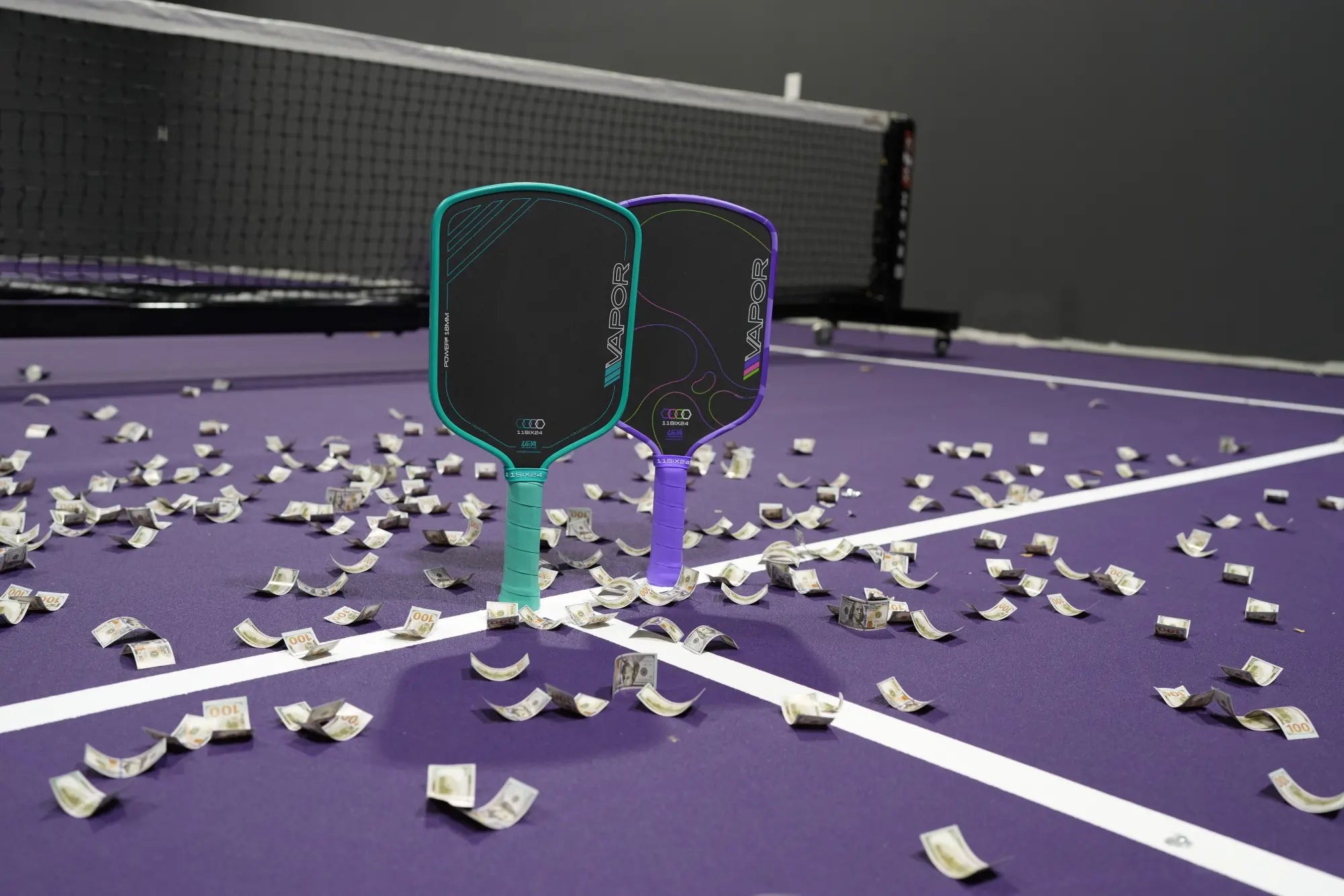 Two Vapor paddles standing on a purple court covered in hundred-dollar bills